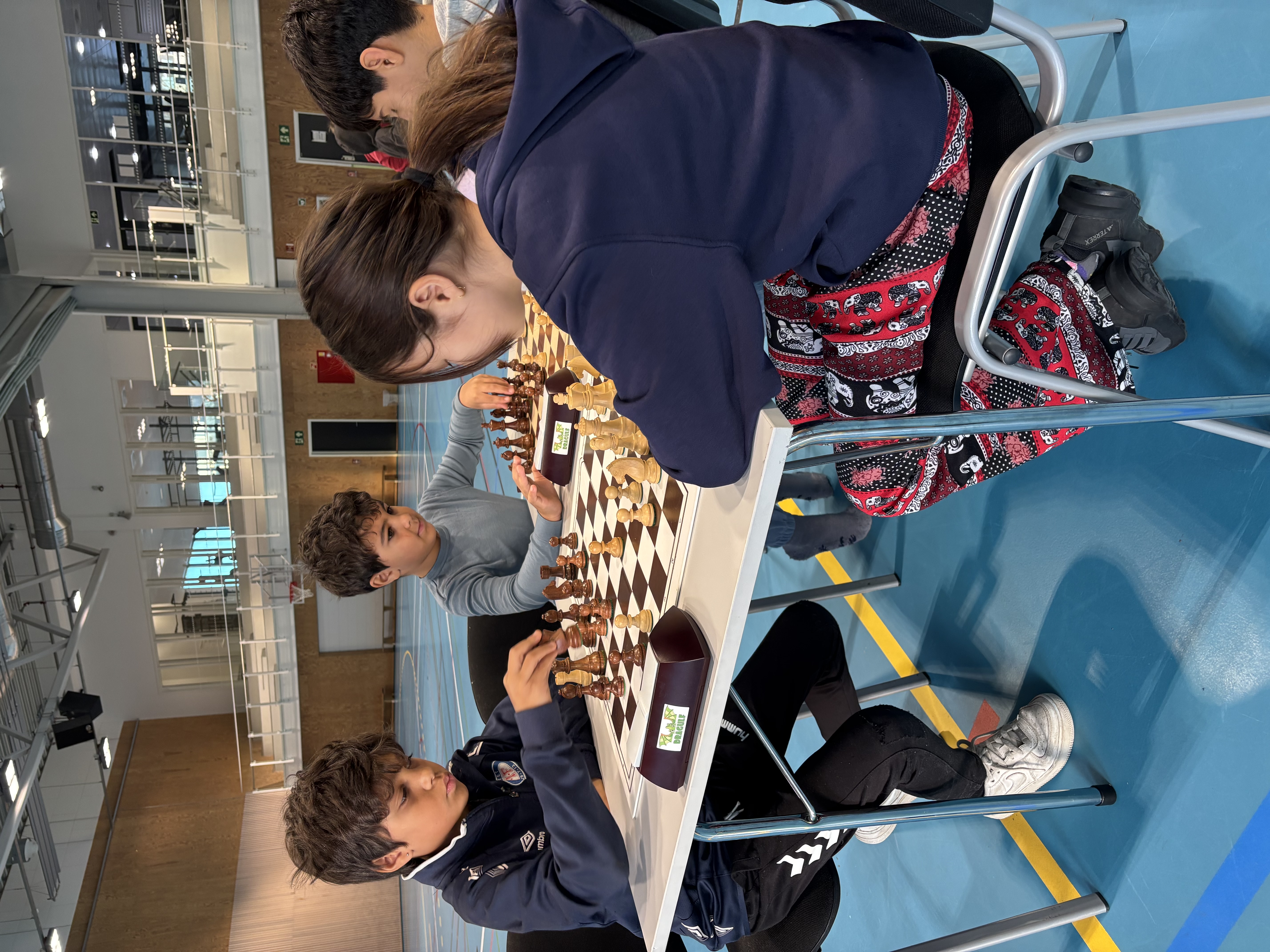 en gruppe mennesker som står i et rom med et stort hvitt bord og stoler